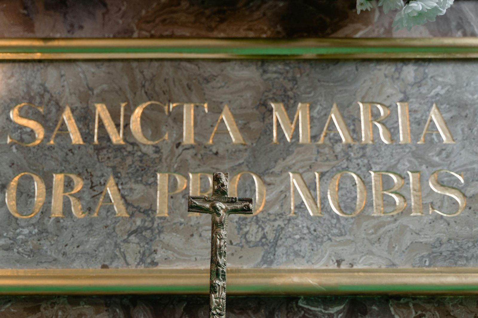 Crucifix before marble inscription representing Catholic catechesis and formation